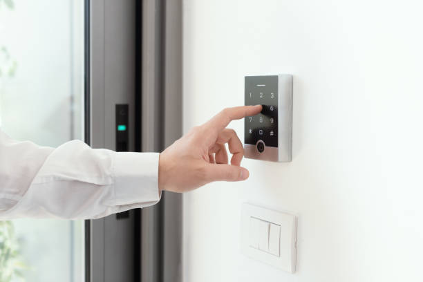 Person aktiviert eine Alarmsystem über ein Bedienfeld zur Sicherung des Hauses.